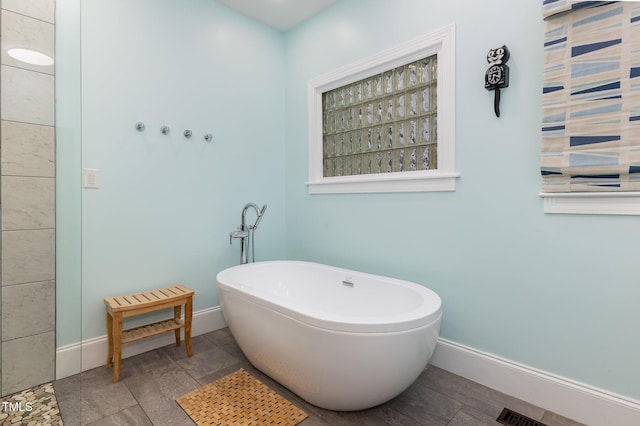 7901 Farnham Ct, Raleigh, NC 27615 - bathroom with baseboards, a freestanding bath, and visible vents