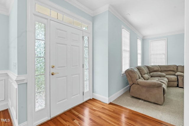 entryway with crown molding, wood finished floors, and baseboards