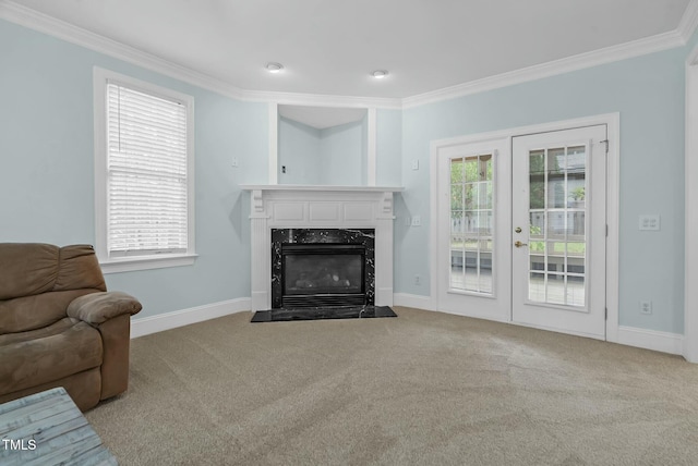 carpeted living room featuring baseboards, ornamental molding, and plenty of natural light