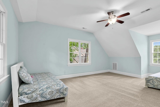carpeted bedroom with a ceiling fan, visible vents, lofted ceiling, and baseboards