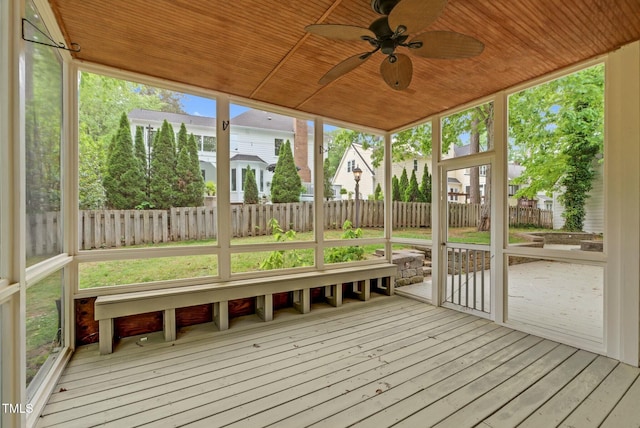 unfurnished sunroom with ceiling fan and a residential view