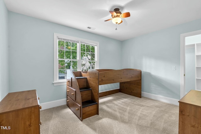 unfurnished bedroom featuring baseboards, visible vents, a ceiling fan, and carpet flooring