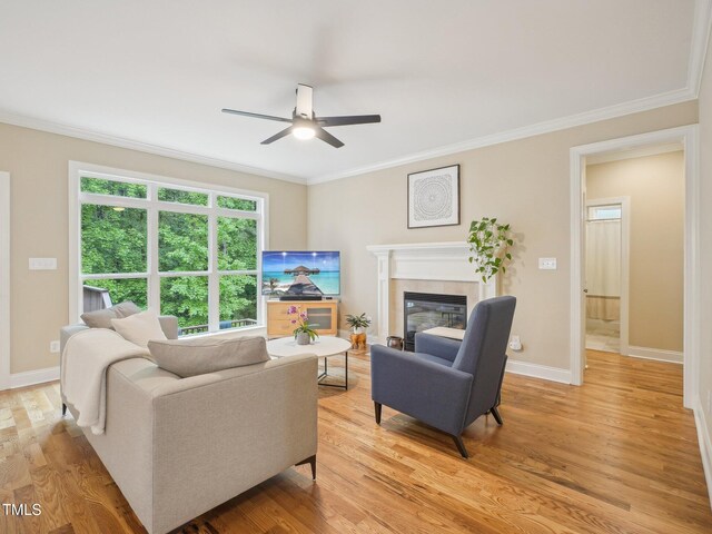4125 Enfield Ridge Dr, Cary, NC 27519 - living room with a ceiling fan, ornamental molding, a tile fireplace, light wood finished floors, and baseboards