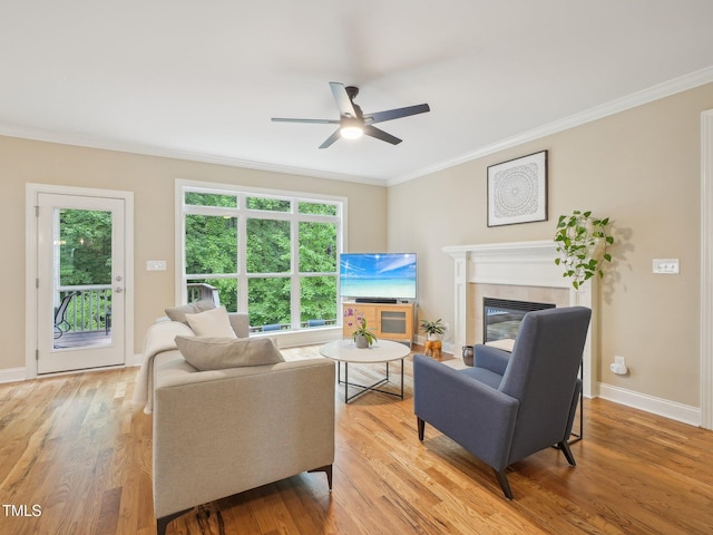 4125 Enfield Ridge Dr, Cary, NC 27519 - living room featuring ornamental molding, ceiling fan, light wood-type flooring, a tile fireplace, and baseboards