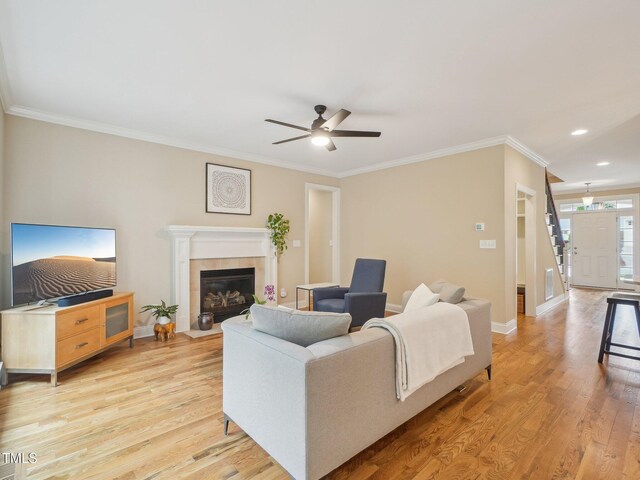4125 Enfield Ridge Dr, Cary, NC 27519 - living room with a ceiling fan, crown molding, light wood finished floors, baseboards, and a tile fireplace