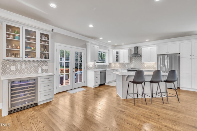 725 S State St, Raleigh, NC 27601 - kitchen featuring beverage cooler, backsplash, light countertops, appliances with stainless steel finishes, and a breakfast bar area