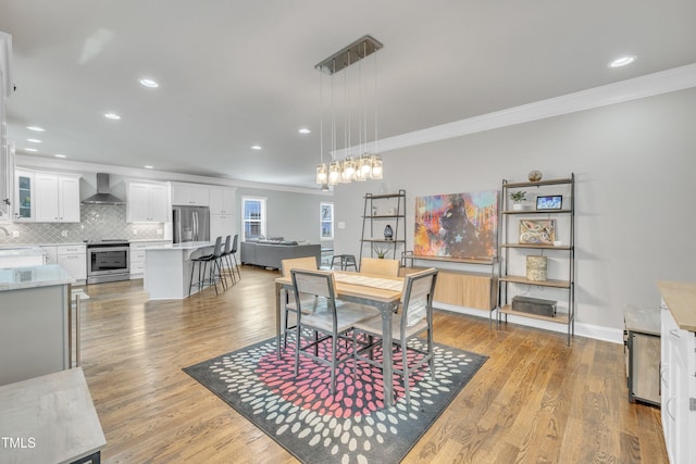 725 S State St, Raleigh, NC 27601 - dining room featuring light wood-type flooring, baseboards, recessed lighting, and crown molding