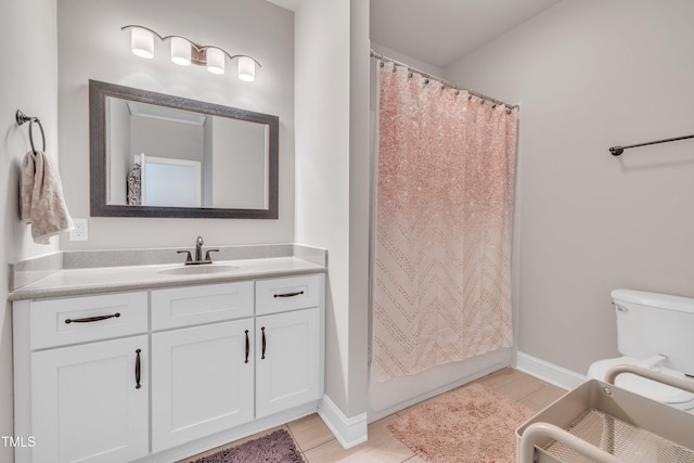 725 S State St, Raleigh, NC 27601 - full bath with baseboards, toilet, vanity, and wood finished floors