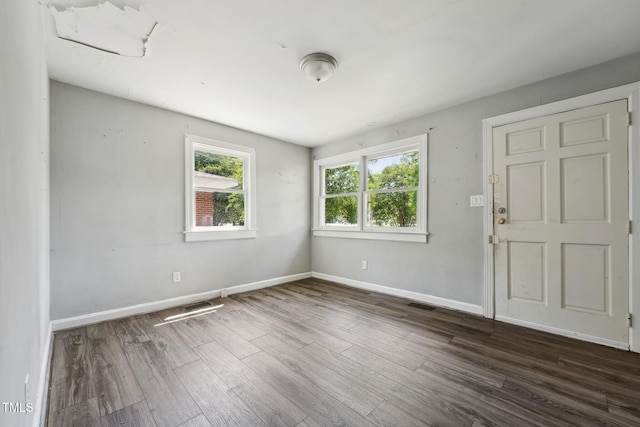unfurnished room with dark wood-style flooring and baseboards