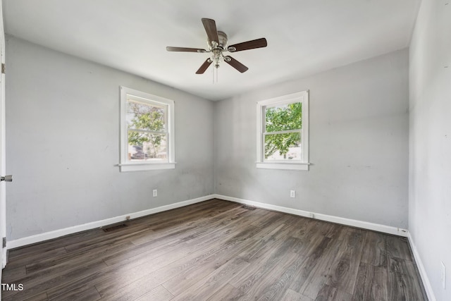 unfurnished room featuring plenty of natural light, wood finished floors, a ceiling fan, and baseboards