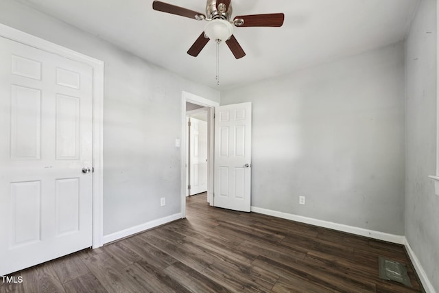 unfurnished bedroom featuring baseboards, dark wood-style floors, and ceiling fan