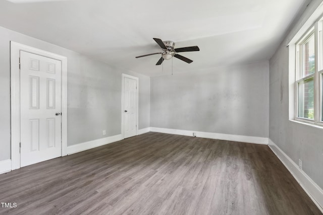 unfurnished bedroom featuring wood finished floors, baseboards, a ceiling fan, and a closet