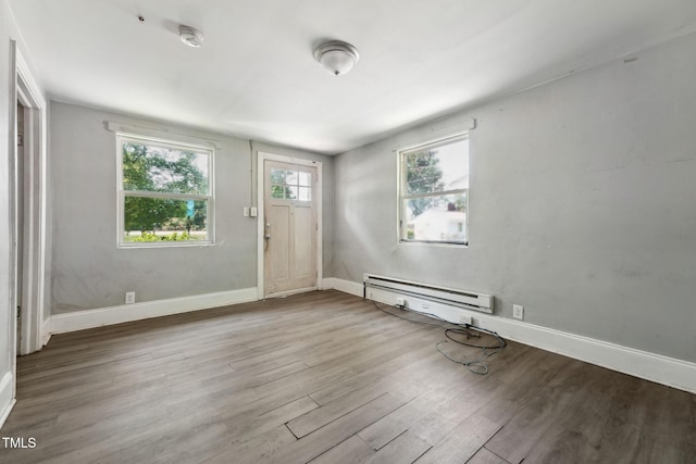 foyer featuring wood finished floors, a baseboard radiator, and baseboards