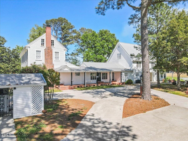 7348 NC-222 Hwy, Stantonsburg, NC 27883 - view of front of home featuring a chimney, driveway, a porch, metal roof, and a standing seam roof
