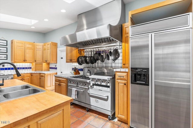 7348 NC-222 Hwy, Stantonsburg, NC 27883 - kitchen featuring a skylight, high end appliances, backsplash, a sink, and wall chimney exhaust hood
