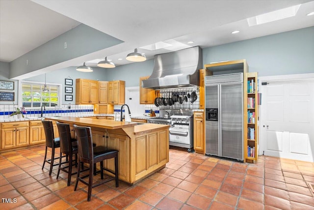 7348 NC-222 Hwy, Stantonsburg, NC 27883 - kitchen with a kitchen island with sink, exhaust hood, butcher block counters, appliances with stainless steel finishes, and backsplash