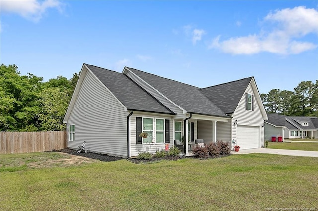 view of front facade with concrete driveway, an attached garage, fence, and a front yard