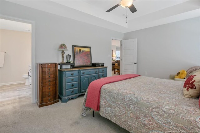 bedroom featuring ceiling fan, light carpet, and ensuite bathroom