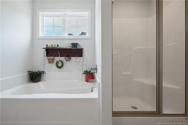 full bath featuring a garden tub and a stall shower