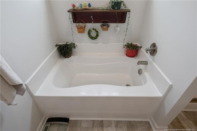 full bathroom featuring a bath and wood finished floors