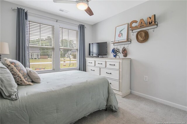 bedroom with visible vents, a ceiling fan, baseboards, and light carpet