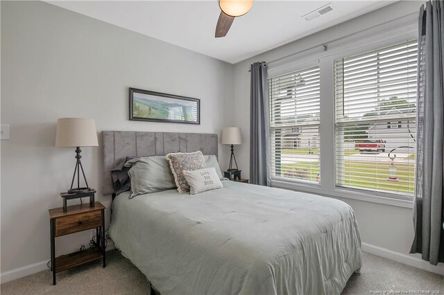 bedroom featuring light colored carpet, ceiling fan, baseboards, and visible vents
