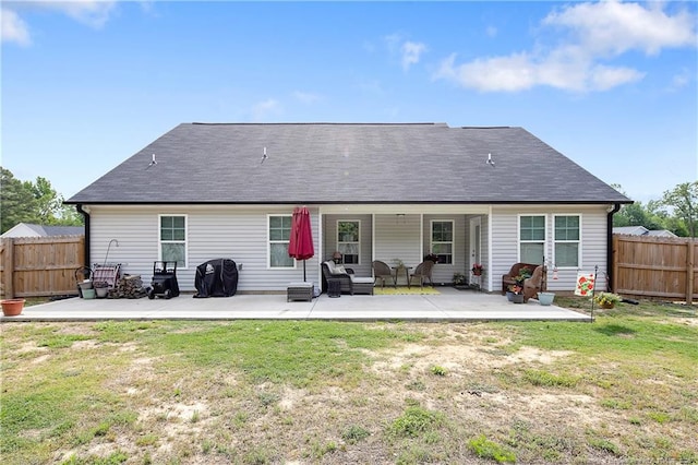 rear view of property featuring a fenced backyard, outdoor lounge area, a yard, and a patio