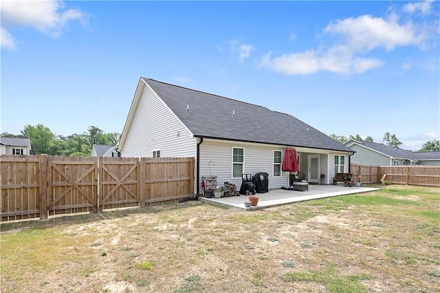 back of house with a gate, a fenced backyard, a yard, a patio, and roof with shingles