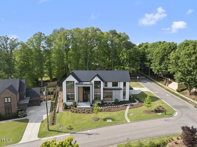 view of front facade with metal roof and a front lawn