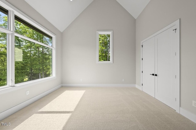 unfurnished bedroom featuring baseboards, lofted ceiling, and carpet