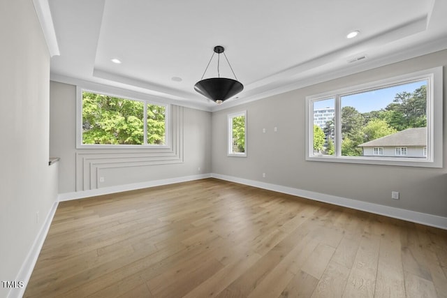 spare room featuring recessed lighting, a raised ceiling, visible vents, baseboards, and hardwood / wood-style floors