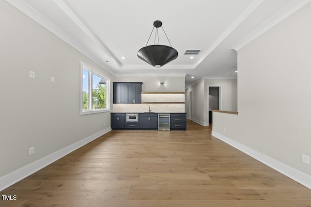 unfurnished living room with recessed lighting, wine cooler, ornamental molding, visible vents, and a tray ceiling