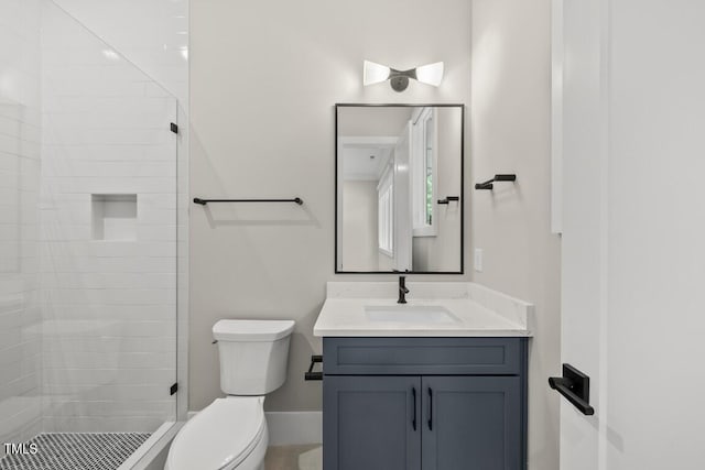 bathroom with a shower stall, toilet, and vanity