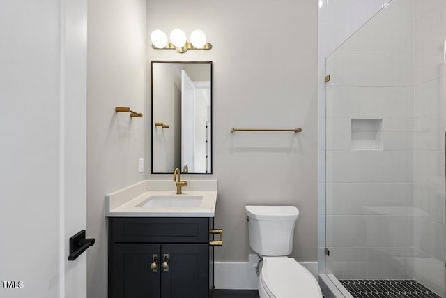 full bath featuring toilet, tiled shower, and vanity