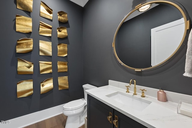 bathroom with toilet, wood finished floors, and vanity