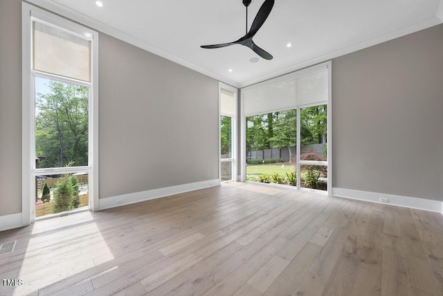 unfurnished room featuring ornamental molding, ceiling fan, wood finished floors, and plenty of natural light