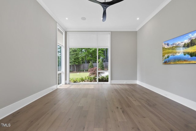 unfurnished room with wood finished floors, recessed lighting, ornamental molding, and baseboards