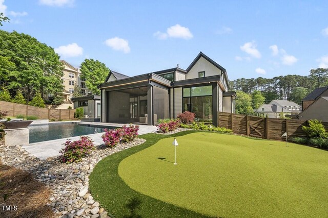 back of house with a patio, a fenced in pool, a fenced backyard, and a sunroom