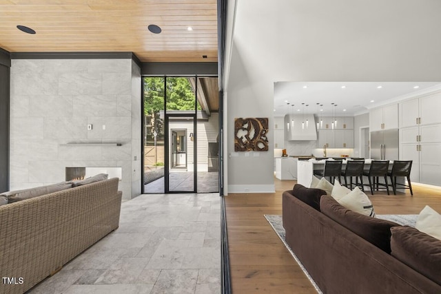 living area with a fireplace, recessed lighting, baseboards, and wooden ceiling