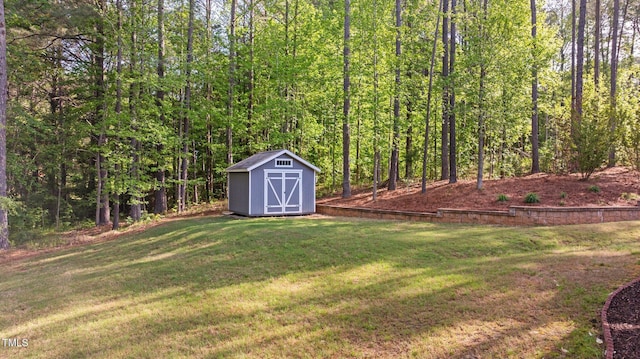 view of yard featuring a view of trees, an outbuilding, and a storage shed