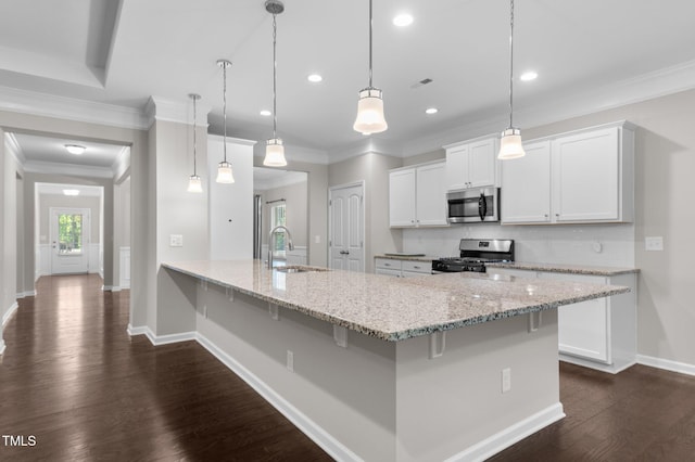 kitchen with a sink, a breakfast bar area, appliances with stainless steel finishes, baseboards, and dark wood-style flooring