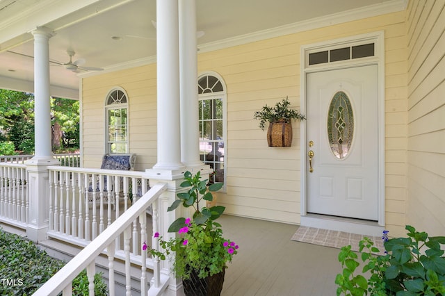 view of exterior entry with a porch and ceiling fan