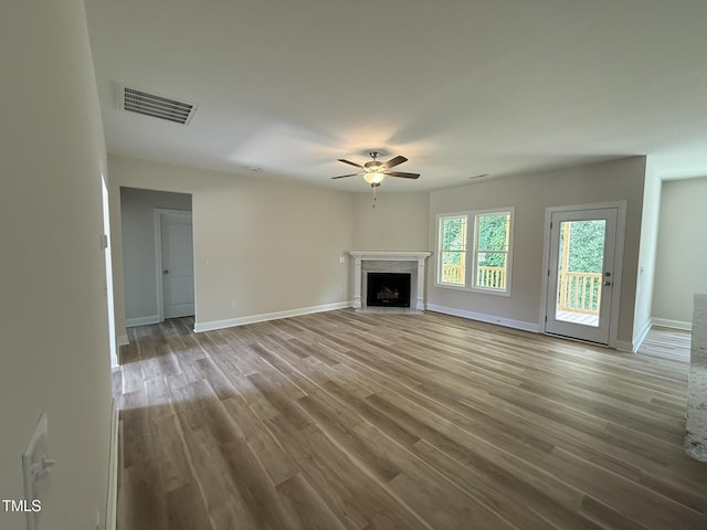 93 Hot Springs Way, Benson, NC 27504 - unfurnished living room featuring a ceiling fan, wood finished floors, and a fireplace with flush hearth