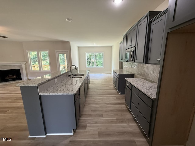 93 Hot Springs Way, Benson, NC 27504 - kitchen with stainless steel microwave, light stone counters, plenty of natural light, tasteful backsplash, and recessed lighting