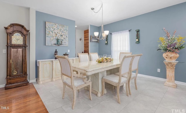 dining space featuring a chandelier and baseboards