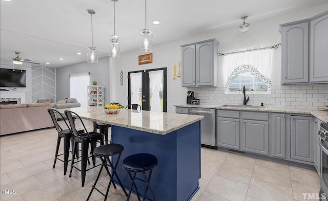 kitchen featuring appliances with stainless steel finishes, gray cabinetry, plenty of natural light, and a sink