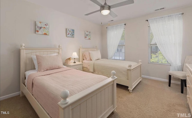 bedroom with visible vents, ceiling fan, light colored carpet, and baseboards