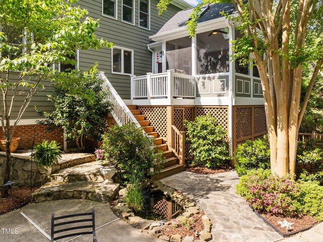 exterior space featuring roof with shingles, stairs, and a sunroom