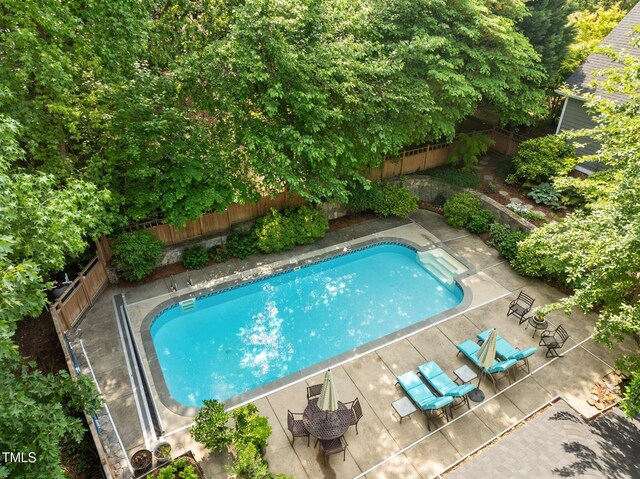 view of swimming pool featuring a fenced backyard, a fenced in pool, and a patio