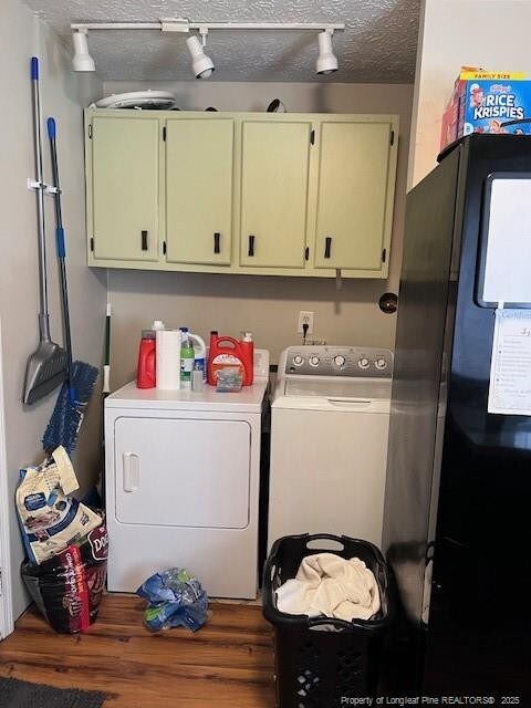 clothes washing area featuring track lighting, wood finished floors, independent washer and dryer, cabinet space, and a textured ceiling